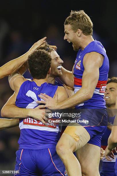 Marcus Bontempelli of the Bulldogs celebrates with with Tom Liberatore and Jake Stringer after he kicks the ball for a match sealing goal during the...