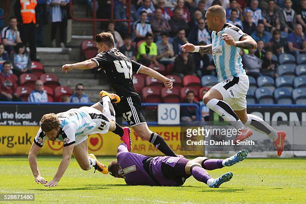 Jed Steer of Huddersfield Town FC saves a goal as Martin Cranie and Joel Lynch of Huddersfield Town FC leap over him during the Sky Bet Championship...