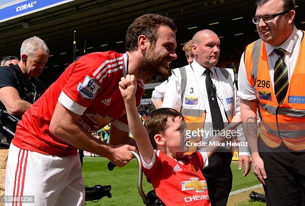 Juan Mata of Manchester United with a fan celebrate their win after the Barclays Premier League match between Norwich City and Manchester United at...
