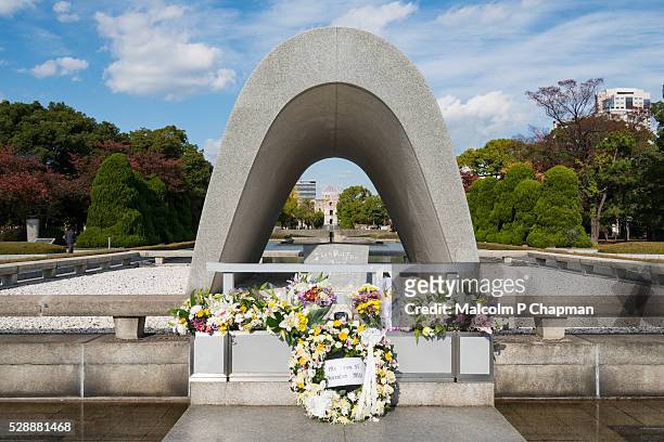 cenotaph and a bomb dome, hiroshima peace memorial, hiroshima - hiroshima peace memorial park stock pictures, royalty-free photos & images