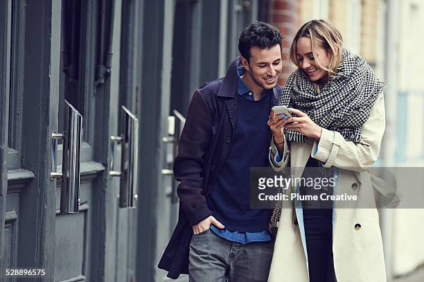 couple with smart phone - couple smartphone stockfoto's en -beelden