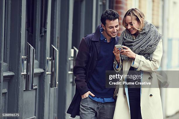 couple with smart phone - couple with smart phone stock pictures, royalty-free photos & images