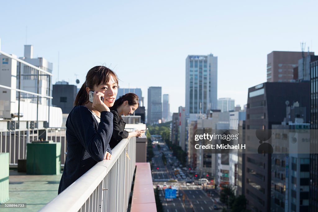 Young woman talking on smartphone on rooftop
