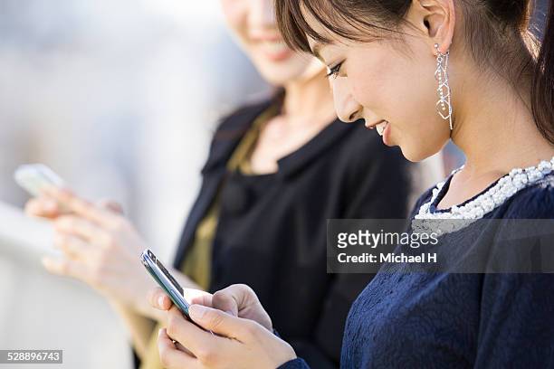 young woman checking a smartphone - social media profile stock pictures, royalty-free photos & images
