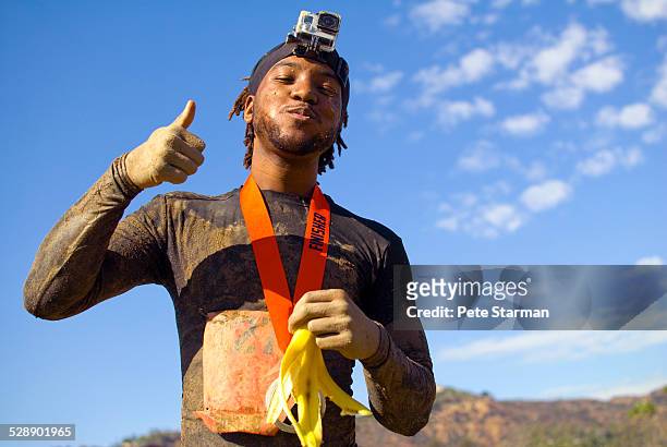 african american 5k competitor at finish of race. - sportsperson medal stock pictures, royalty-free photos & images