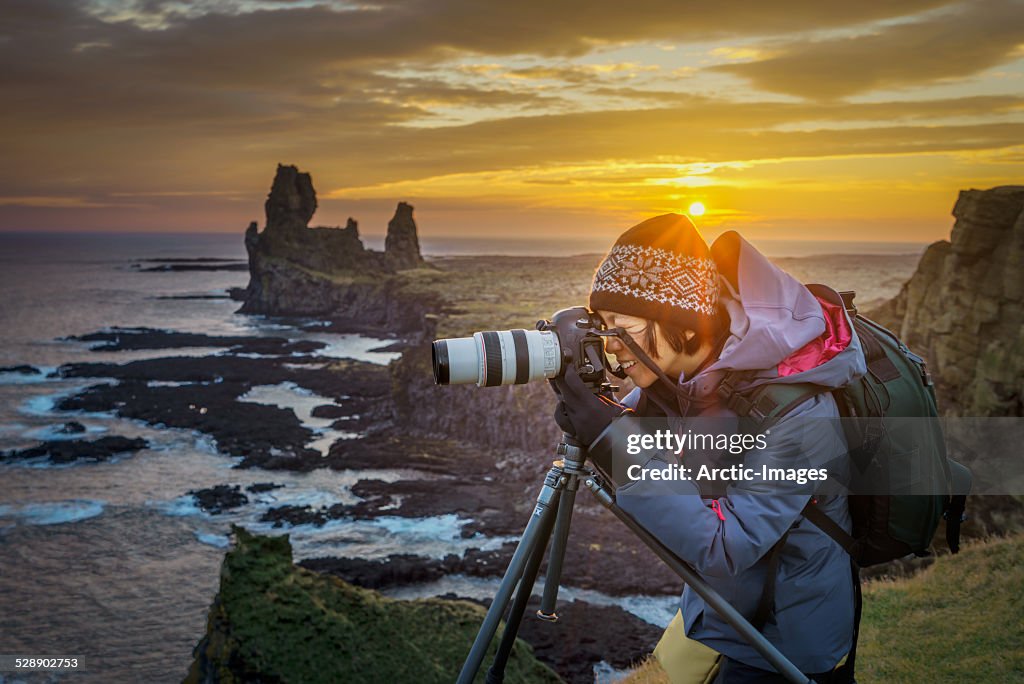Photographer taking pictures at sunset, Iceland