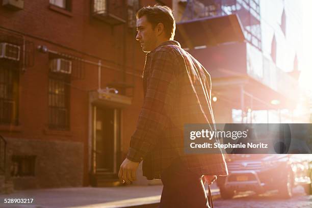 man crossing the street in urban setting - cool cars ストックフォトと画像