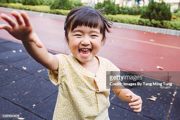 Toddler smiling joyfully at the camera in park