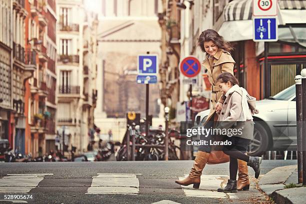 brunette mother daughter walking in paris streets on spring afternoon - fashionable mom stock pictures, royalty-free photos & images