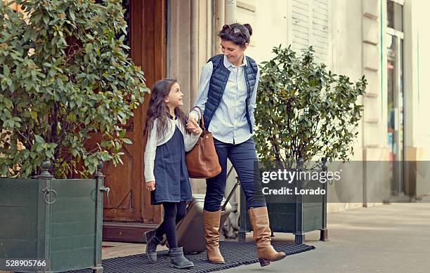 brunette mère et fille marchant dans les rues de paris après-midi au printemps - stéréotype de la classe moyenne photos et images de collection