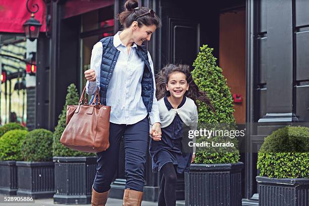 brunette mother daughter walking in paris streets on spring afternoon - premium access images stock pictures, royalty-free photos & images