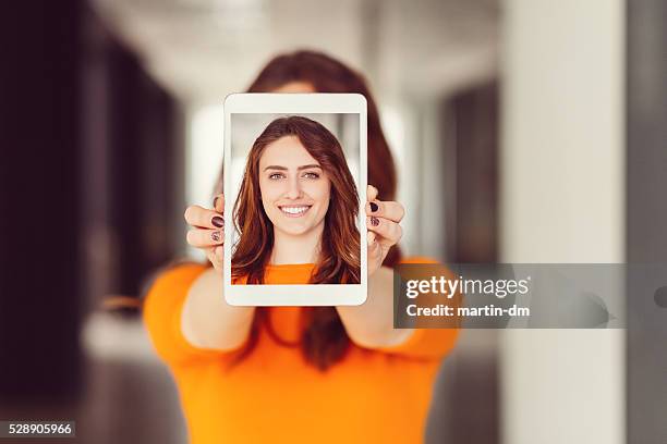 jeune femme montrant autoportrait sur une tablette pc - femme visage caché photos et images de collection