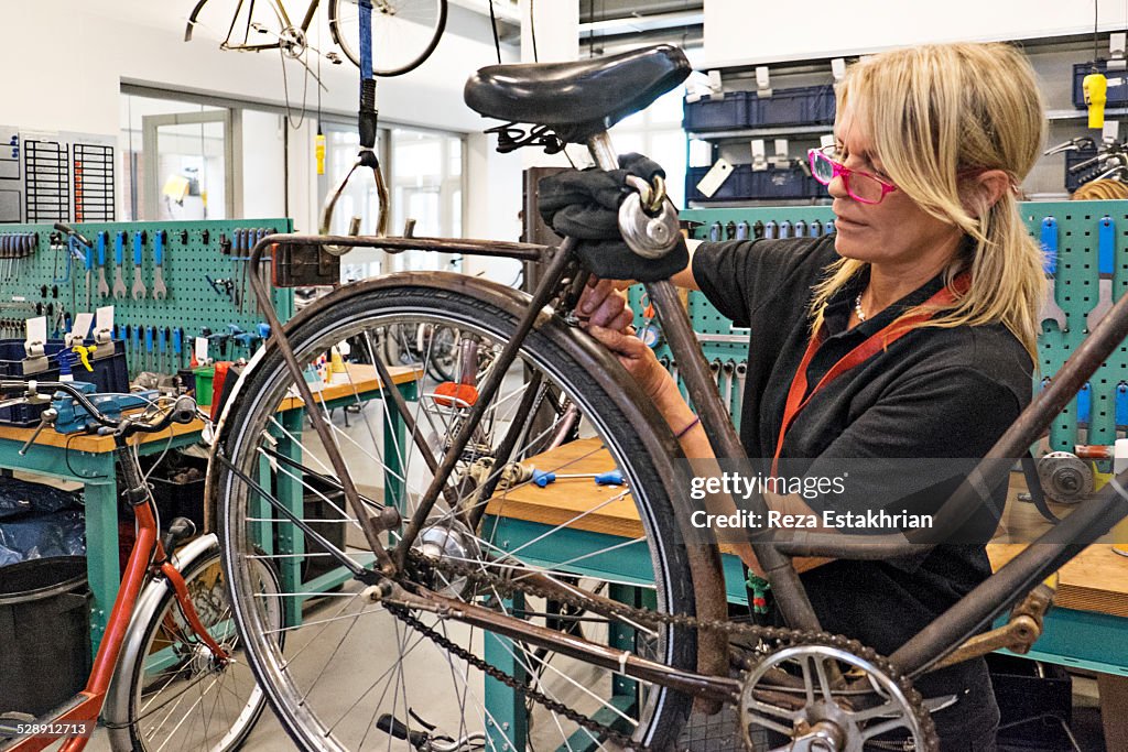 Woman repairs bicycle