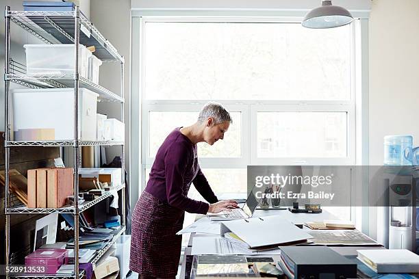 business woman using a laptop in creative space. - purple blouse stock pictures, royalty-free photos & images