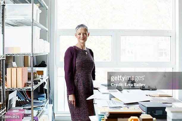 portrait of a business woman in creative office. - purple dress stockfoto's en -beelden