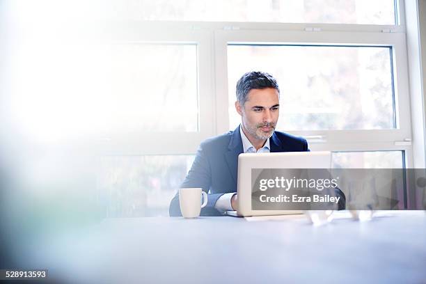 businessman working on a laptop with a coffee. - businessman stock pictures, royalty-free photos & images