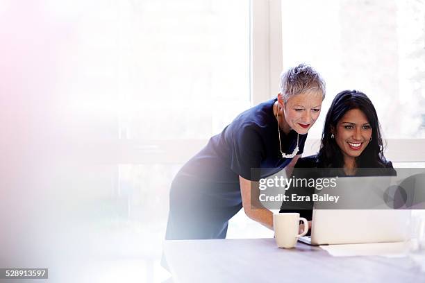 mature business woman mentoring a younger woman. - coacha photos et images de collection