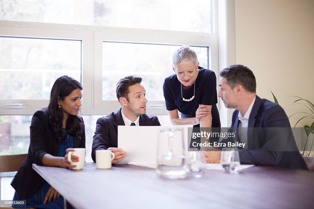Mature business woman in a meeting with employees.