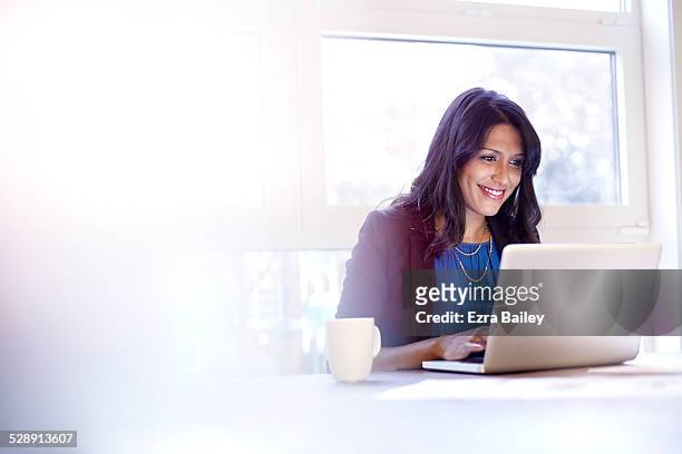 young business woman working on a laptop. - luce vivida foto e immagini stock