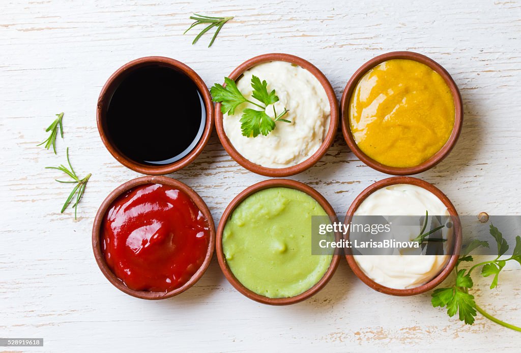 Sauces ketchup, mustar, mayonnaise, wasabi, soy sauce in clay bowls