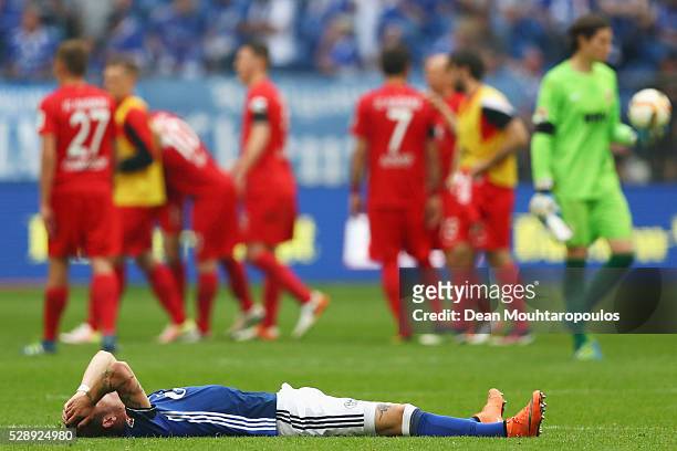 Roman Neustadter of Schalke on the ground looks dejected after the referee blows the whistle signaling the end of the game during the Bundesliga...