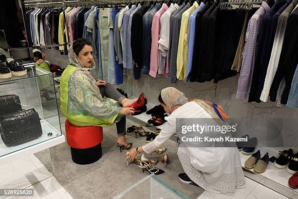 Young woman shops for famous international brand high heel shoes in the newly opened Palladium shopping mall on April 28, 2016 in Tehran, Iran....