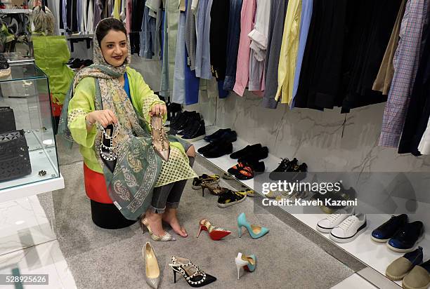 Young woman shops for famous international brand shoes in the newly opened Palladium shopping mall on April 28, 2016 in Tehran, Iran. Iranians love...