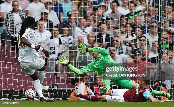 Swansea City's French striker Bafetimbi Gomis shoots past West Ham United's English defender Aaron Cresswell and West Ham United's Irish goalkeeper...