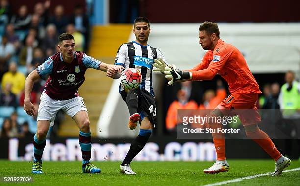 Aleksandar Mitrovic of Newcastle United competes for the ball against Ciaran Clark and Mark Bunn of Aston Villa during the Barclays Premier League...