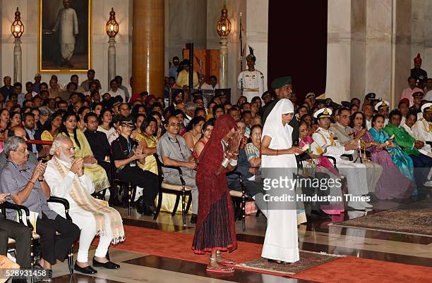 Mother and wife of Sepoy Dharma Ram of Mahar Regiment stands to receive Shaurya Chakra from President Pranab Mukherjee during a Defence Investiture...