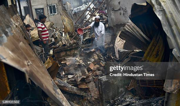 People searching for valuables amid burnt remains of their rooms at Gautam Nagar, Govandi on May 6, 2016 in Mumbai, India. Allegedly the fire broke...