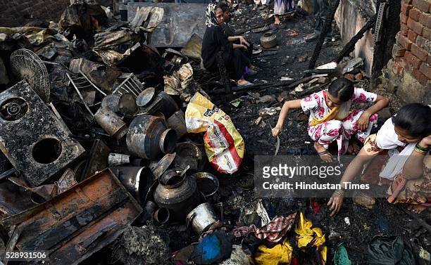 People searching for valuables amid burnt remains of their rooms at Gautam Nagar, Govandi on May 6, 2016 in Mumbai, India. Allegedly the fire broke...