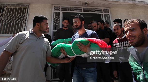 People carry the bodies of three children, namely Nasir, Rehaf and Yusra El Hundi, who lost their lives due to a fire in a house, from morgue of Sifa...
