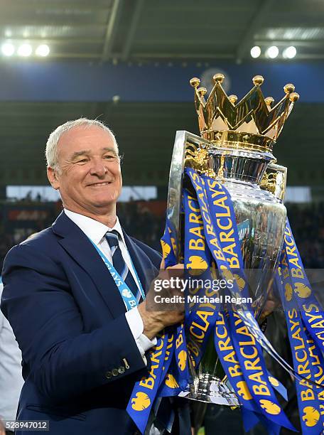 Claudio Ranieri poses for photographs with the Premier League Trophy as players and staffs celebrate the season champions after the Barclays Premier...