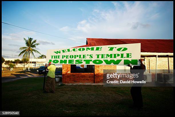 Local tourist office employees prepared to place a sign to mark the site of the Peoples Temple and Jonestown, Guyana, the site of the Jim Jones mass...