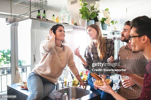 eine gruppe von freunden essen in der küche für die partei - hipster in a kitchen stock-fotos und bilder