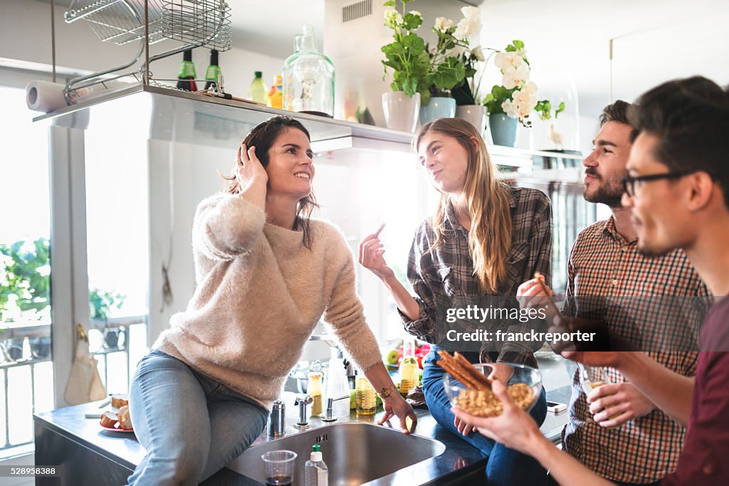 Group of friends eating on the kitchen for the party