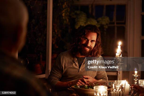 man laughing at dinner in greenhouse - candle light foto e immagini stock