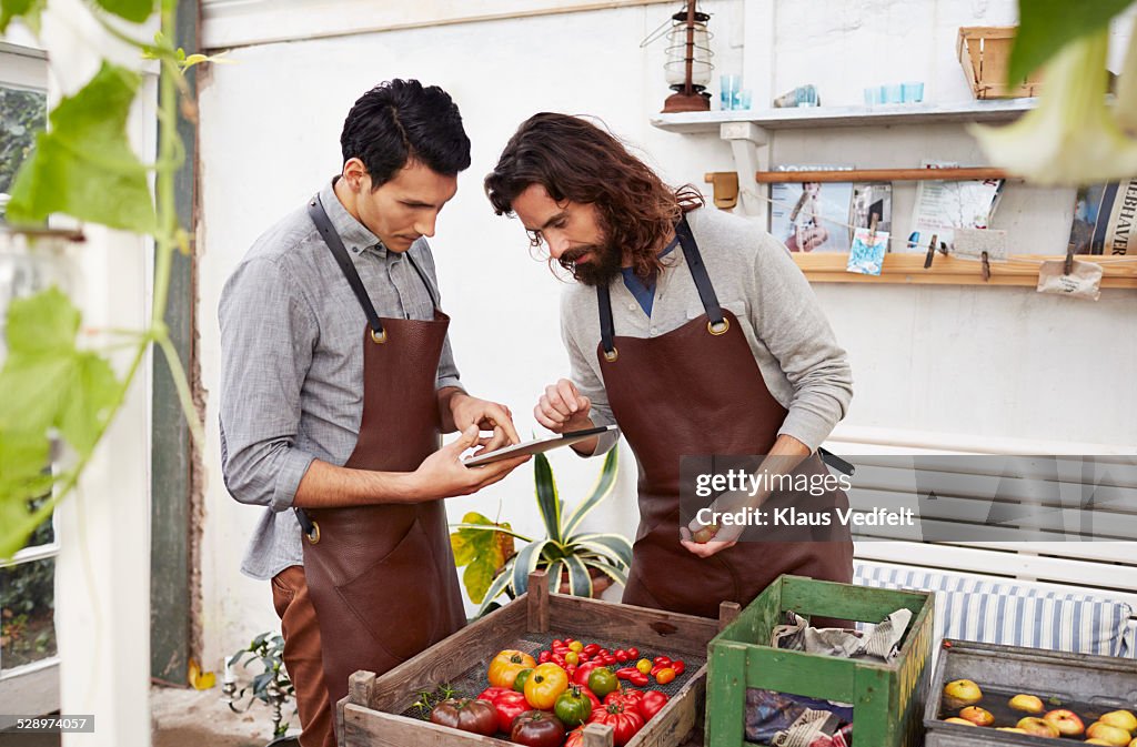 Two guys keeping track of produce with tablet