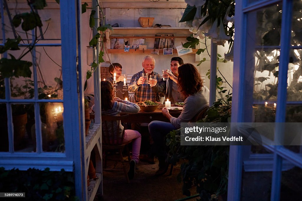 Three generations having cozy meal in garden house