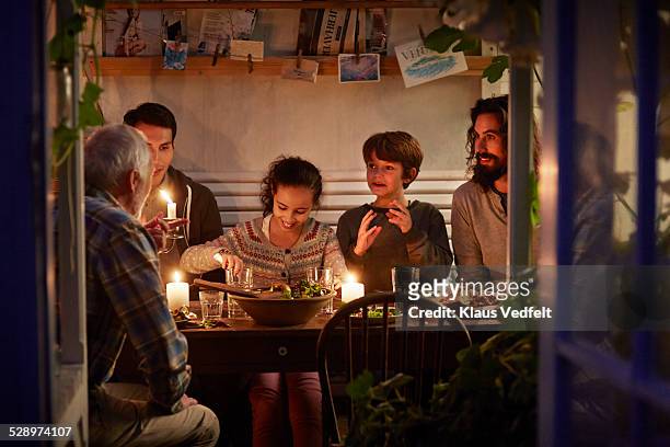family having cozy dinner en garden house - warmes abendessen stock-fotos und bilder