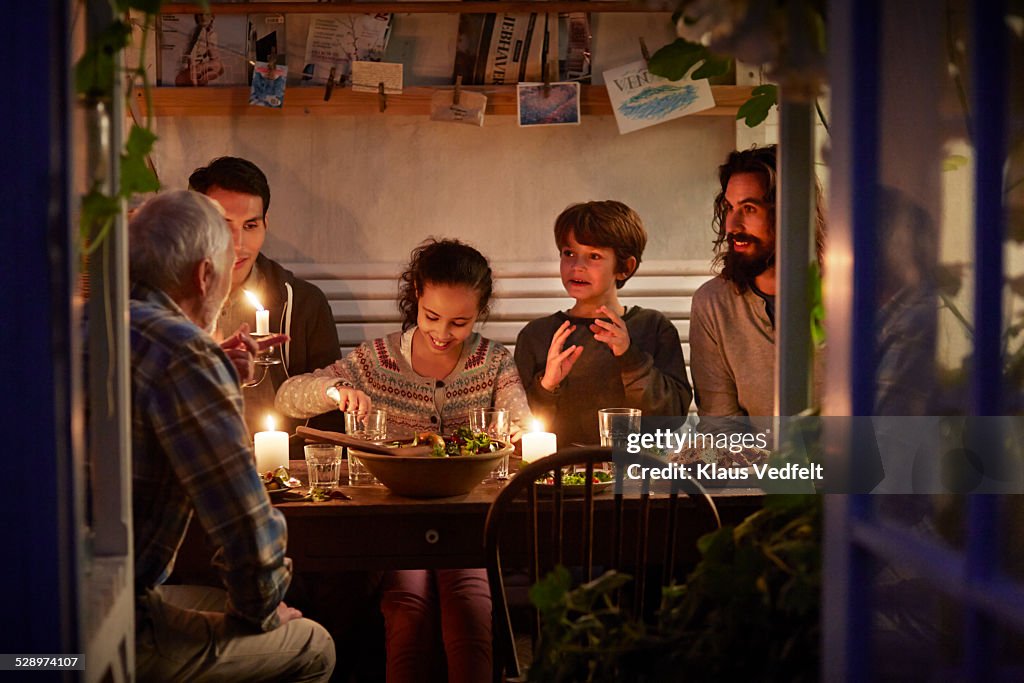 Family having cozy dinner en garden house