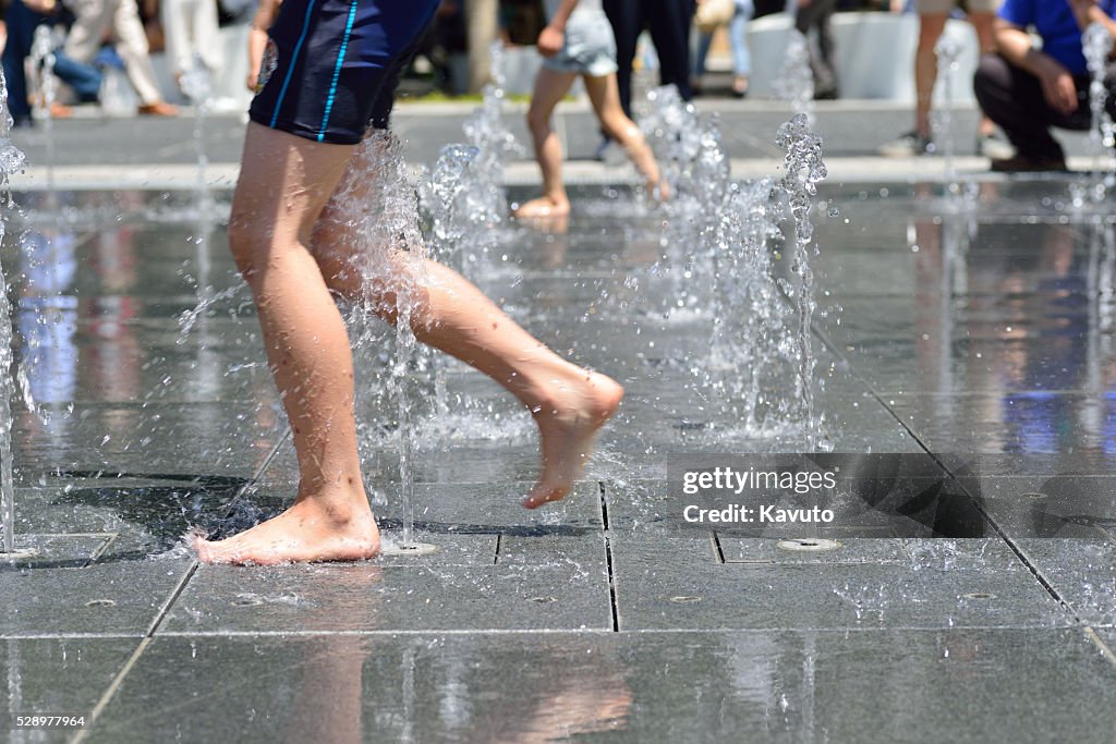 Children playing at fountain in a public park