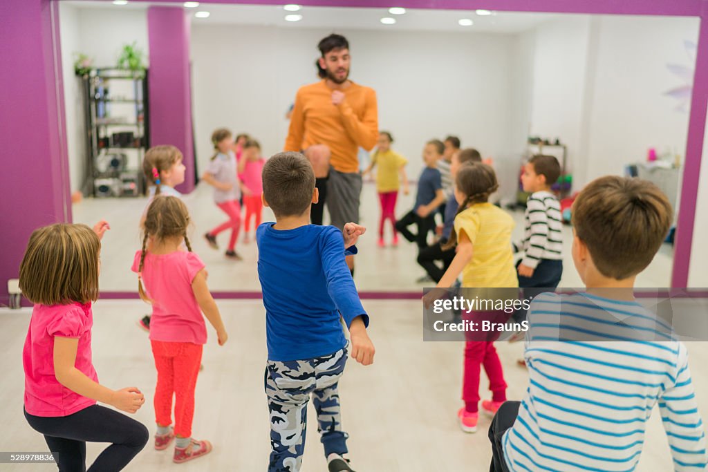Rear view of children doing keep ups on sports training.