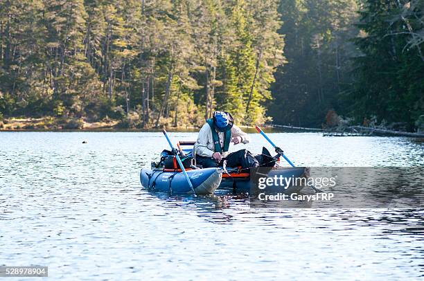 man trout fishing on cleawox lake in inflatable pontoon boat - pontoon boat stock pictures, royalty-free photos & images