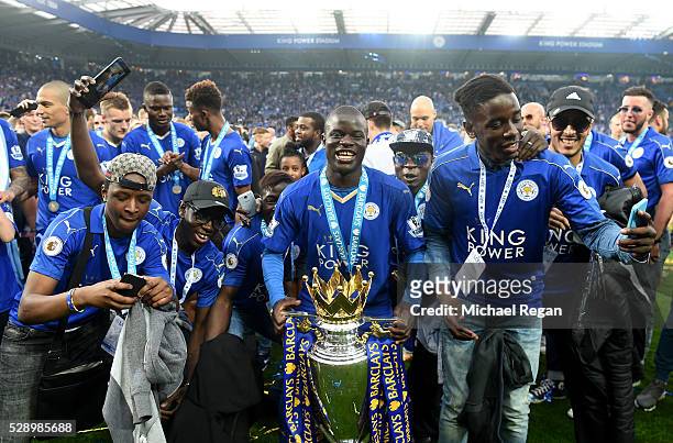 Ngolo Kante of Leicester City poses with the Premier League Trophy with his family as players and staffs celebrate the season champion after the...