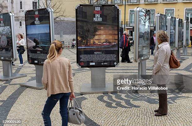 Women watch ‘Aqu�� Morreu Uma Mulher' , a display of photographs and texts denouncing femicide, in Camoes square, Lisbon, Portugal, 16 March 2016. A...