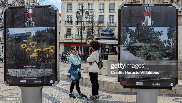 Women watch ‘Aqu�� Morreu Uma Mulher' , a display of photographs and texts denouncing femicide, in Camoes square, Lisbon, Portugal, 16 March 2016. A...