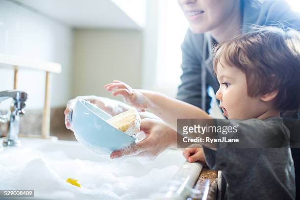 baby dish washing - leanincollection mother stock pictures, royalty-free photos & images