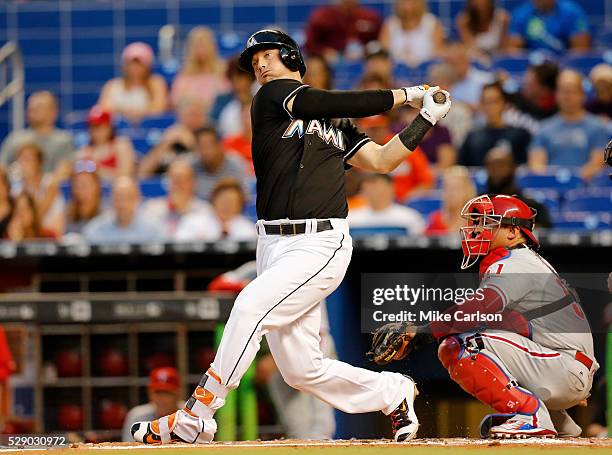 Chris Johnson of the Miami Marlins doubles in front of catcher Carlos Ruiz of the Philadelphia Phillies during the second inning of a game at Marlins...